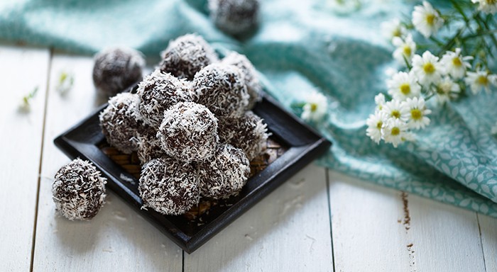 Cocoa and coconut energy balls on white background